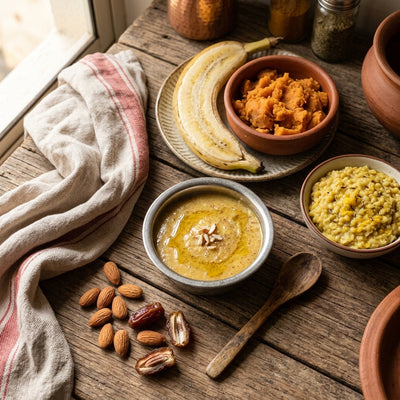 Indian baby weight gain foods flatlay with sprouted ragi porridge, ghee, banana and khichdi