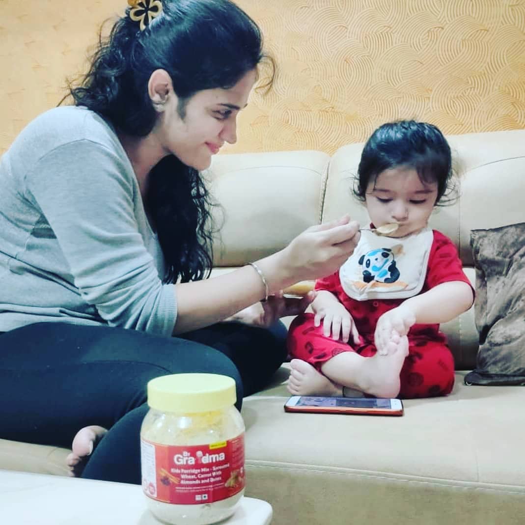 Mother feeding baby ByGrandma porridge
